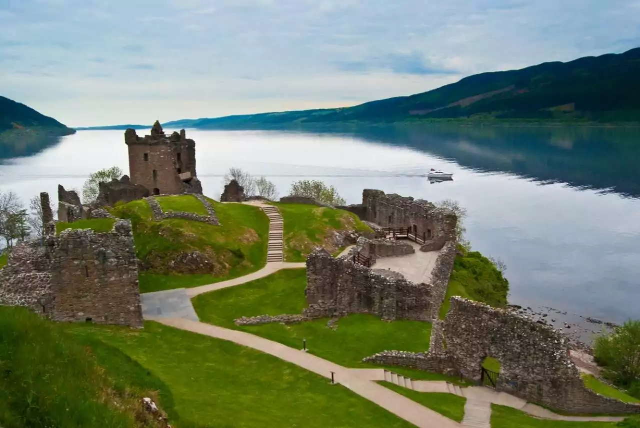 Descubra a Cultura Escocesa dos Clãs de Outlander - castelo Urquhart, com caminho que leva até ele e lago Ness ao fundo