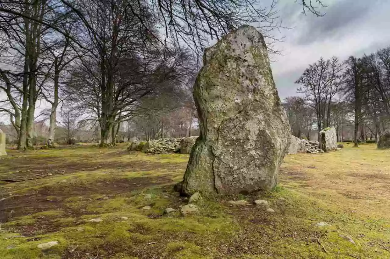 Descubra a Cultura Escocesa dos Clãs de Outlander - Pedra do tamanho de uma pessoa, em Clava Cairns, com natureza em volta