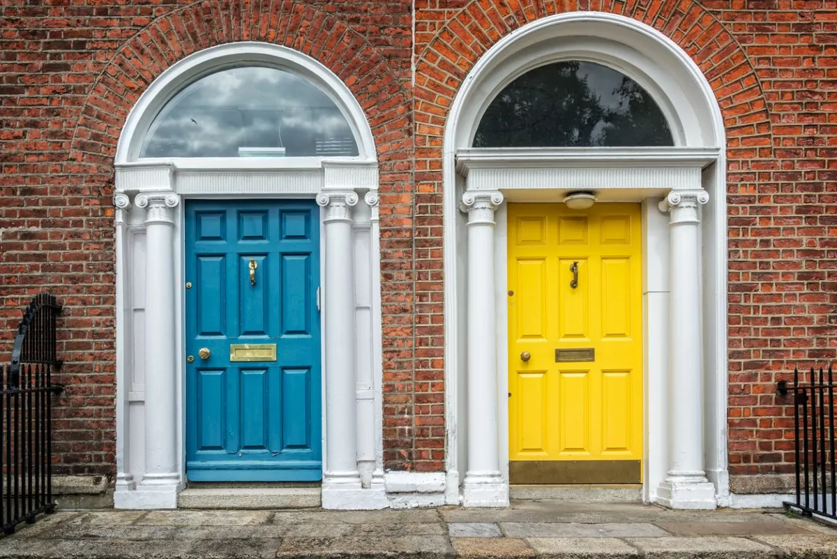 Porta azul e porta amarela de duas tradicionais casas irlandesas