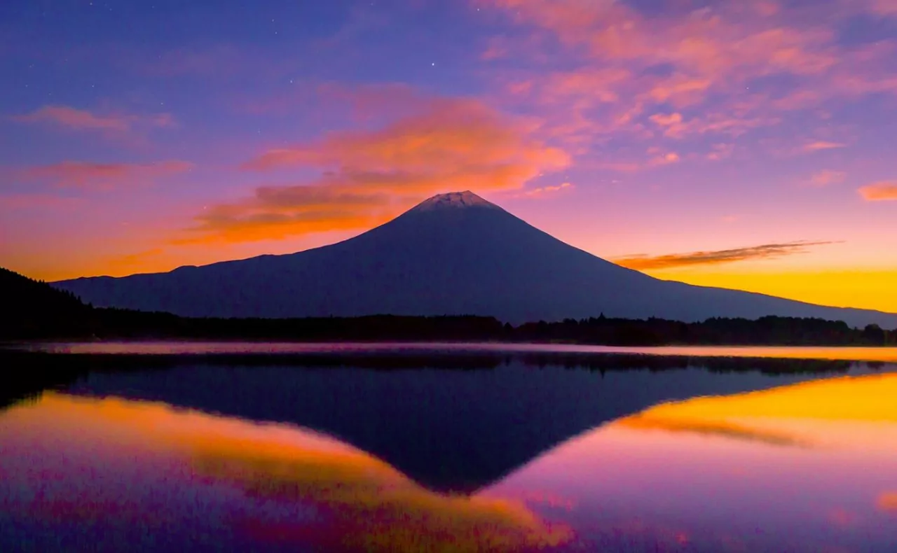 Conheça os melhores lugares para visitar no japão - Vista do Monte Fuji, no Japão, com céu alaranjado e sem o topo de neve