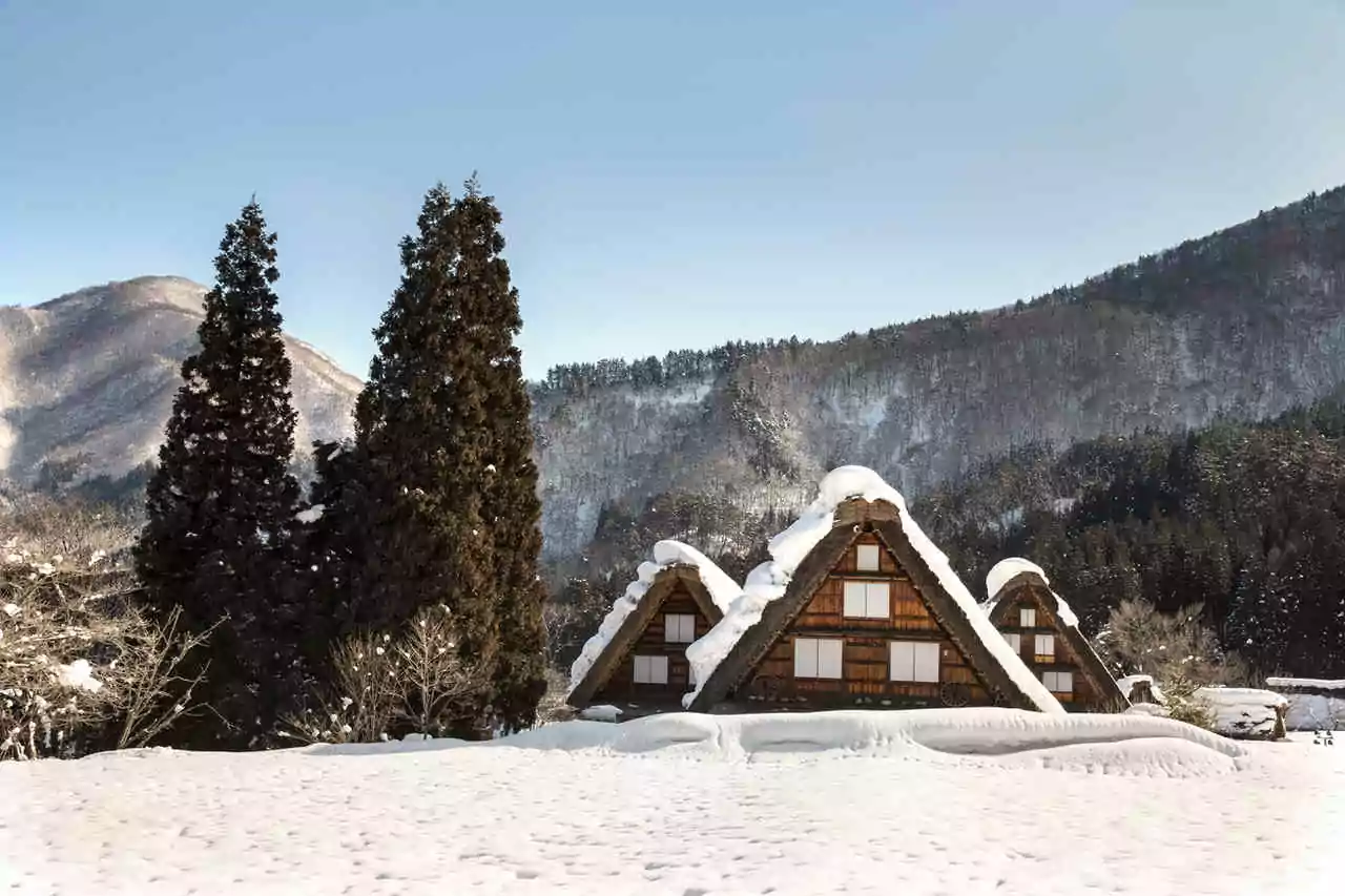 Conheça os melhores lugares para visitar no japão - Casas da Vila Shirikawago no Japão, com neve sobre o telhado que parece duas mãos em oração
