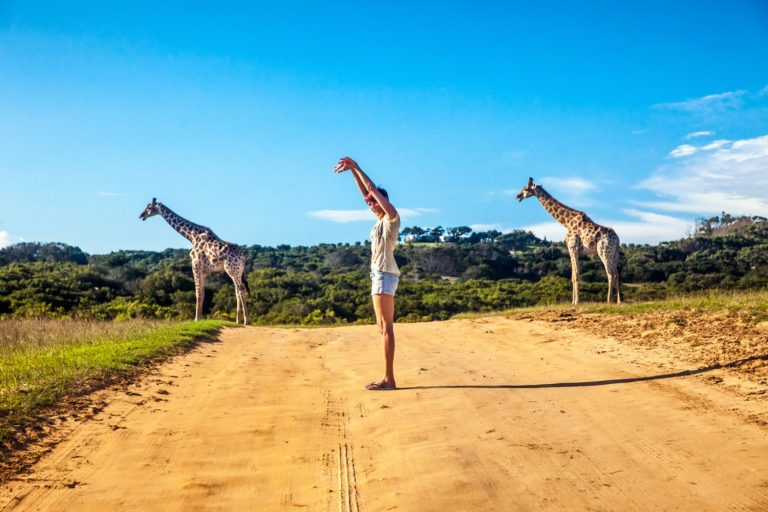 Turismo Ecológico e Sustentável — Como Você Pode Viajar Fora da Caixa! - mulher imitando girafas na savana