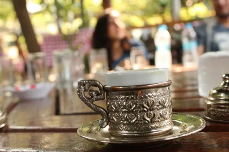 xícara de café turco com fundo de cidade desfocado - Gastronomia e Doces Turcos — 14 Delícias que Você Não Pode Deixar de Provar!
