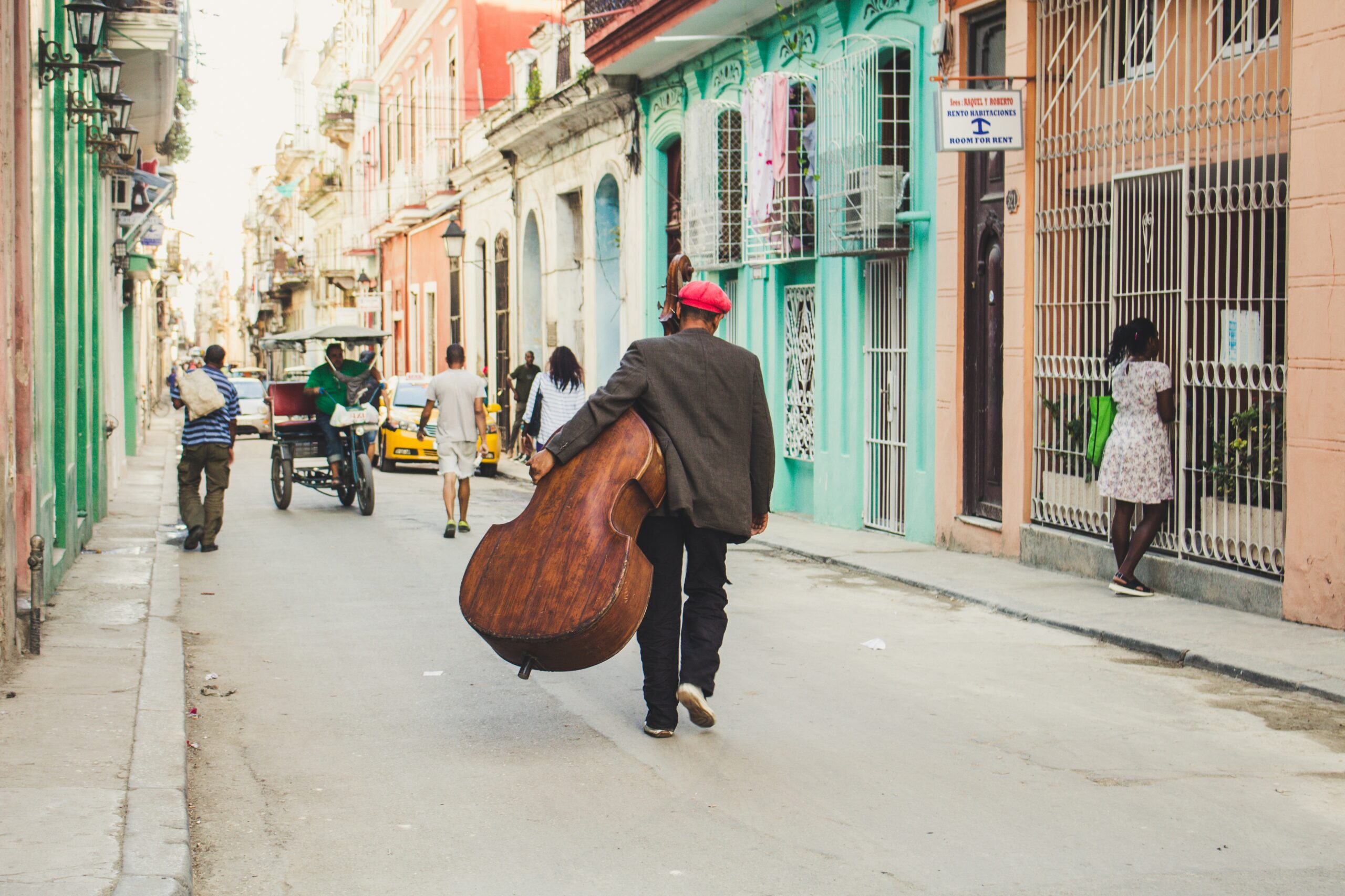 Música de Cuba — homem caminha pelas ruas de Havana com violoncelo.