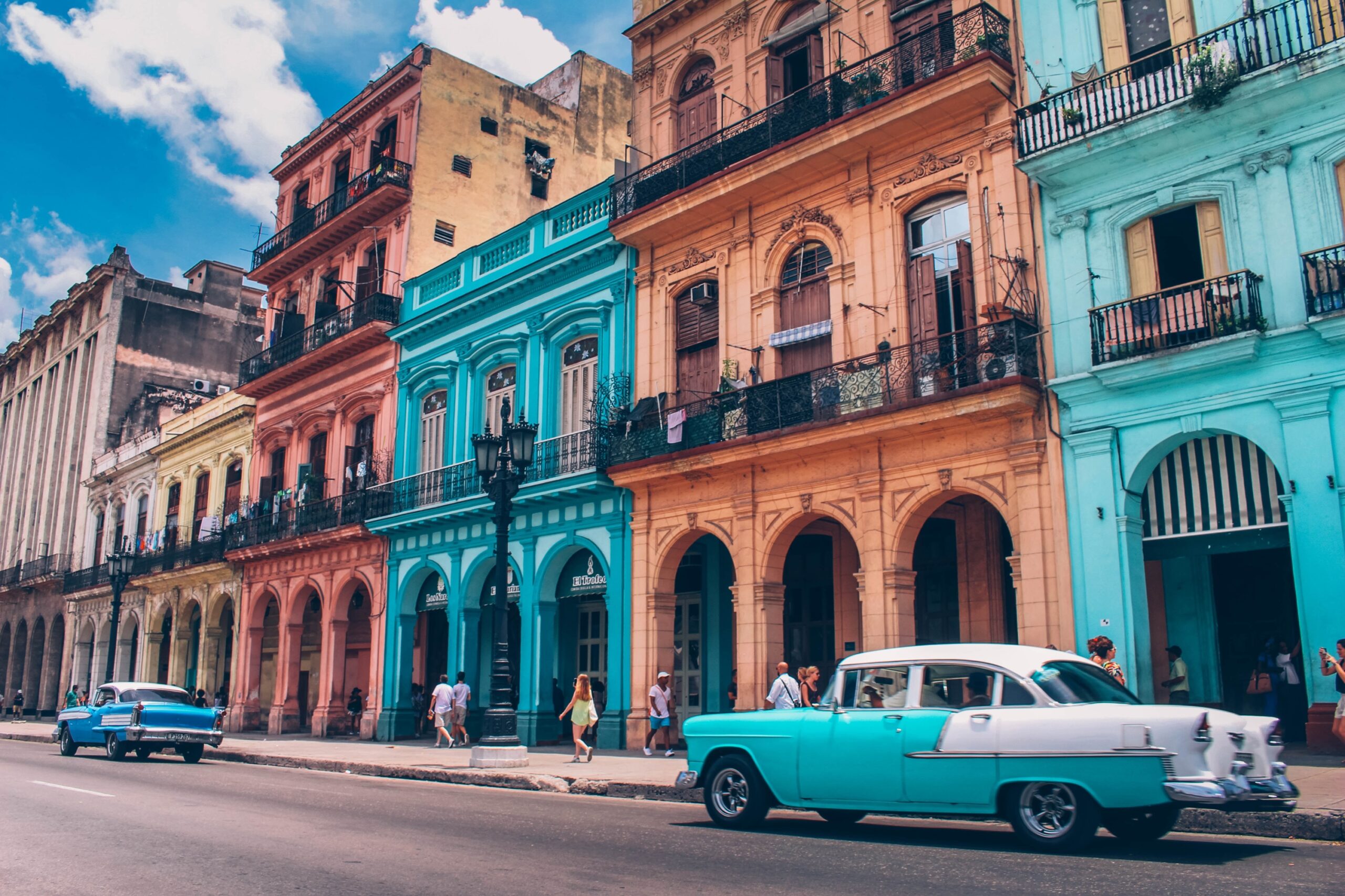 Viagens em 2021. Construção de três andares, antiga, com paredes coloridas de azul, laranja e vermelho. Havana, Cuba.