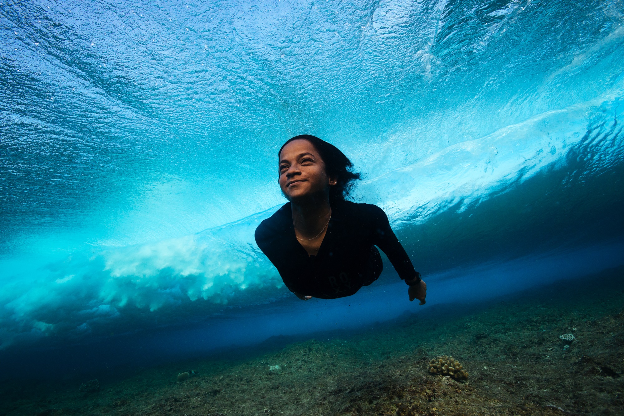 Garota mergulha no oceano das Maldivas, livre do uso de plástico.