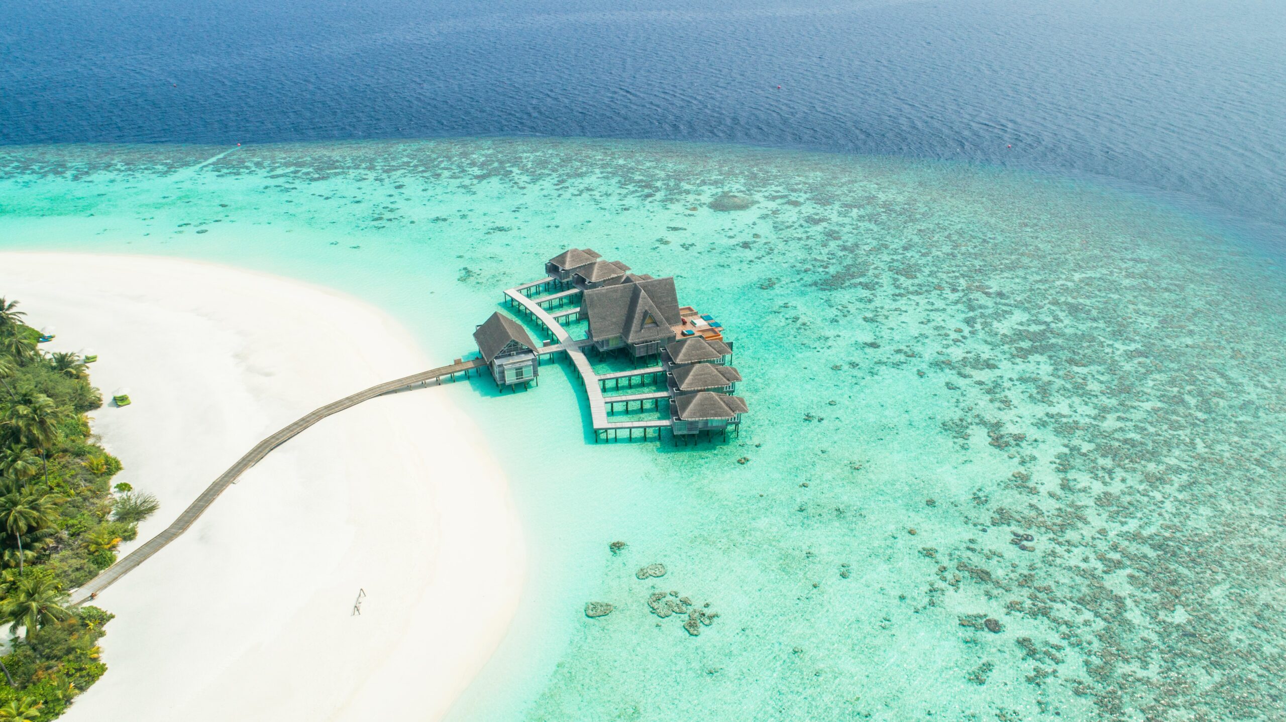 Planejar uma viagem. Foto área das Ilhas Maldivas. Mar azul turquesa e areia branca.