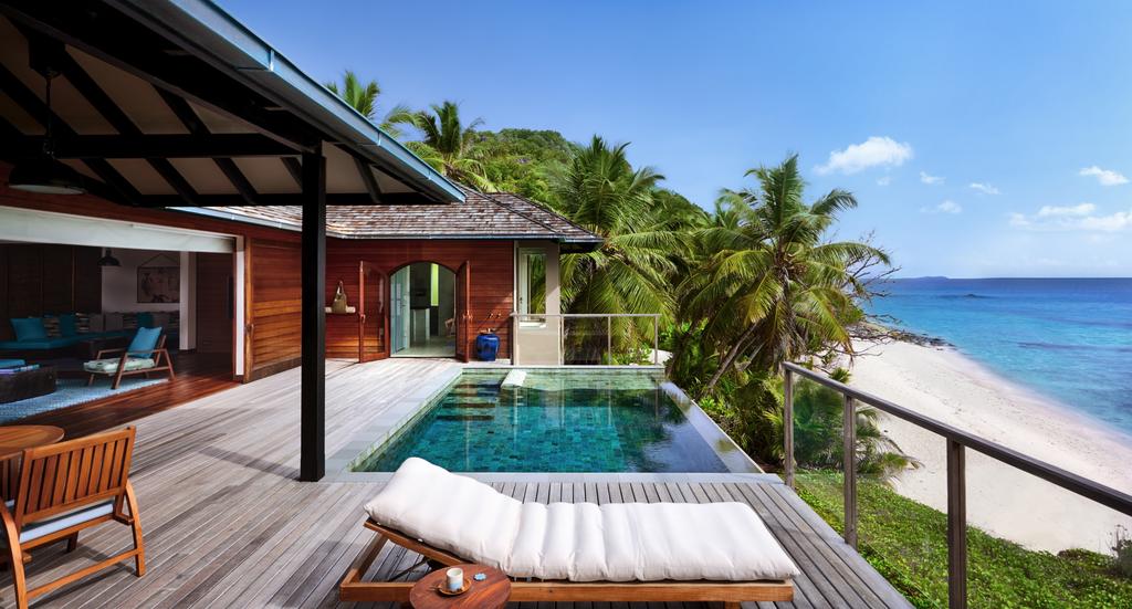 Staycation em Seychelles, no hotel Six Senses. A imagem mostra a varanda de um quarto no hotel, com piscina de borda infinita.