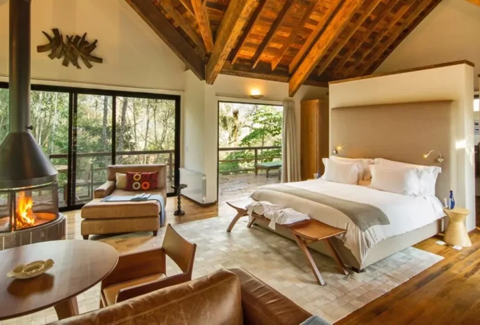 Staycation. Quarto de hotel com portas de vidro, em meio À natureza.