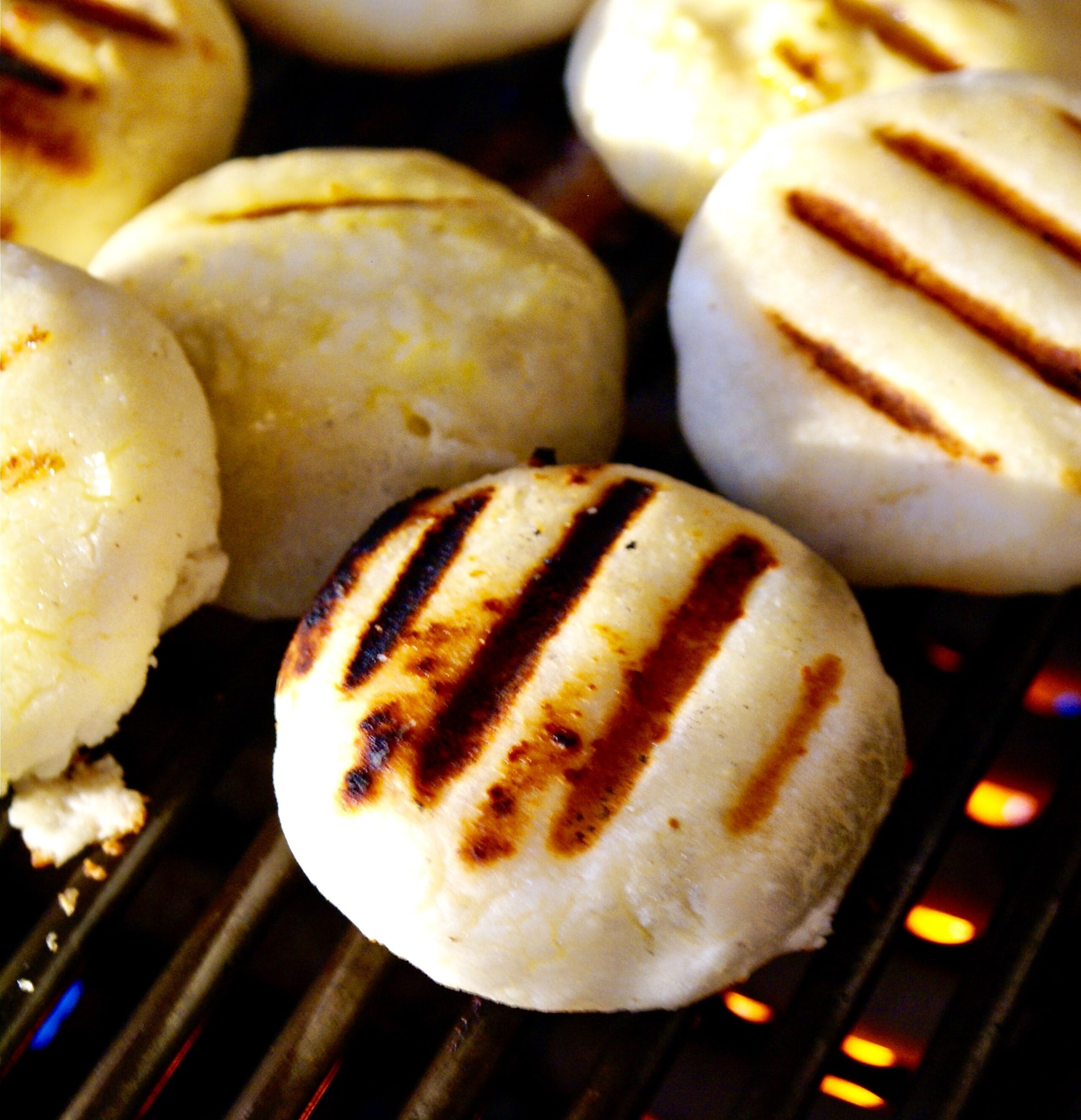 Arepas, que são pãozinhos de Barichara, estão em uma grelha com fogo.