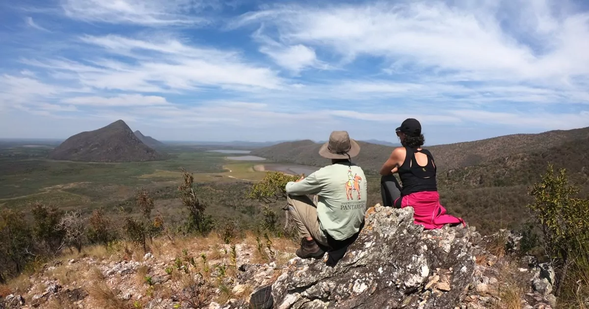 Serra do Amolar. Duas pessoas sentadas de costas em uma pedra, observando o horizonte.
