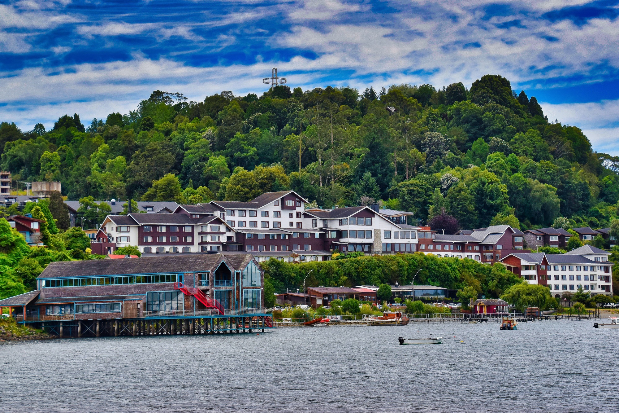 Foto panarômica de parte da cidade de Puerto Varas: casas coloniais de arquitetura alemã estão localizadas na borda de um rio.