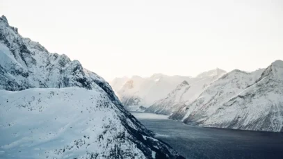 fiordes-noruegueses Fiordes noruegueses: um trecho de água em um corredor entre montanhas cobertas de neve.