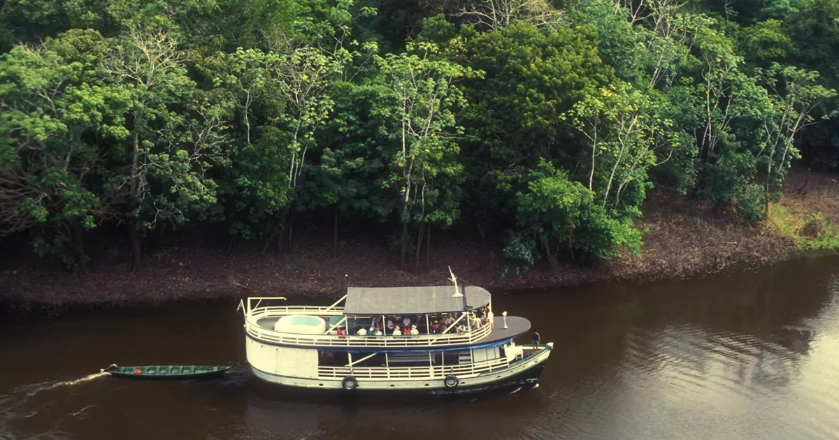 Barco navegando pelo rio na região da Amazônia, um dos melhores destinos do Brasil.