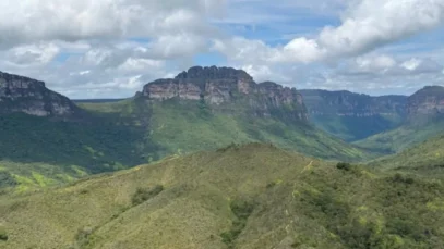 vale-do-pati-trekking Um vale coberto de vegetação está níveis de altura abaixo das montanhas que se erguem a sua volta. Ao fundo, o céu nublado no Vale do Pati.