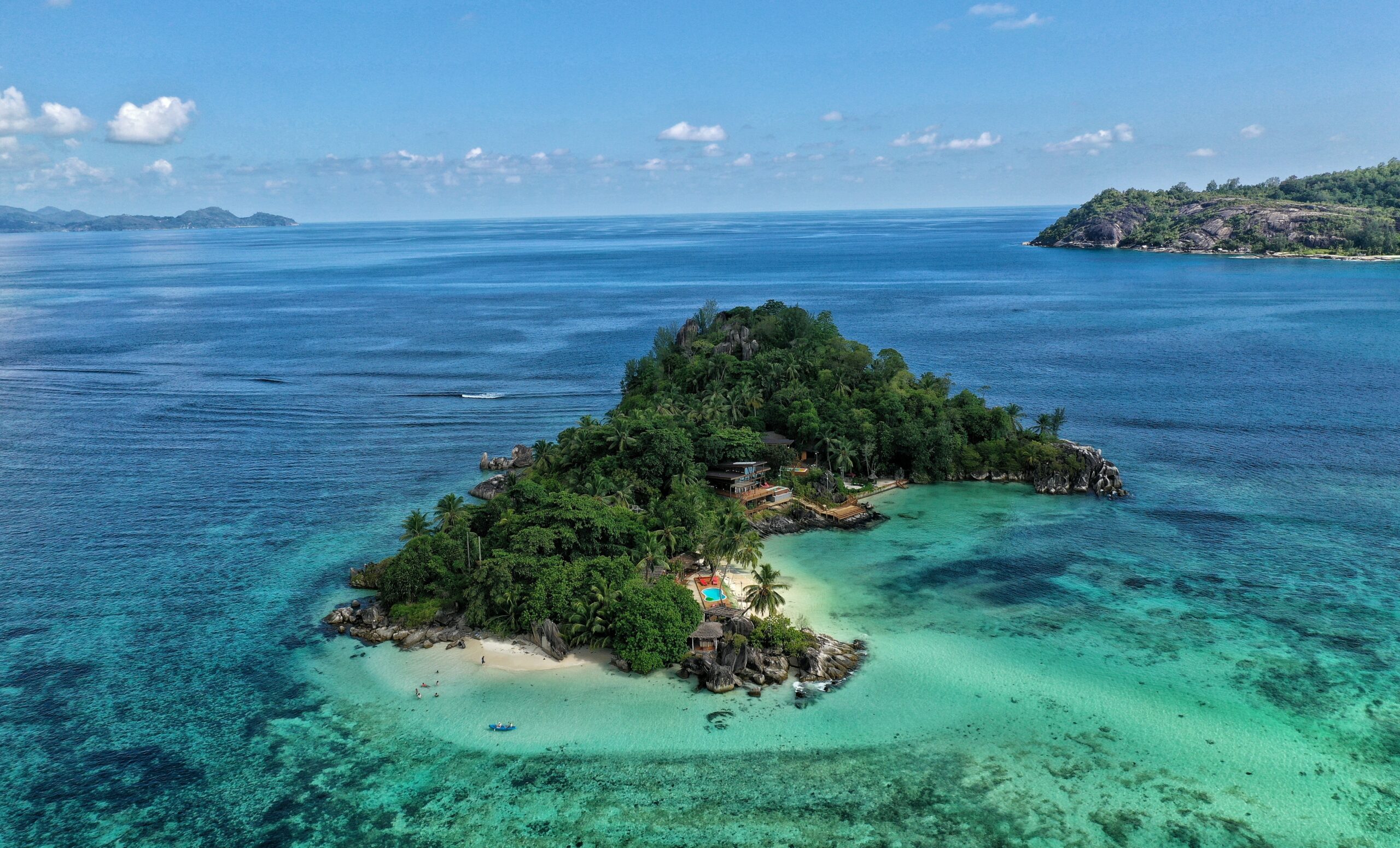 pequena ilha rodeada de praias verdes e mar azul em algum local da África
