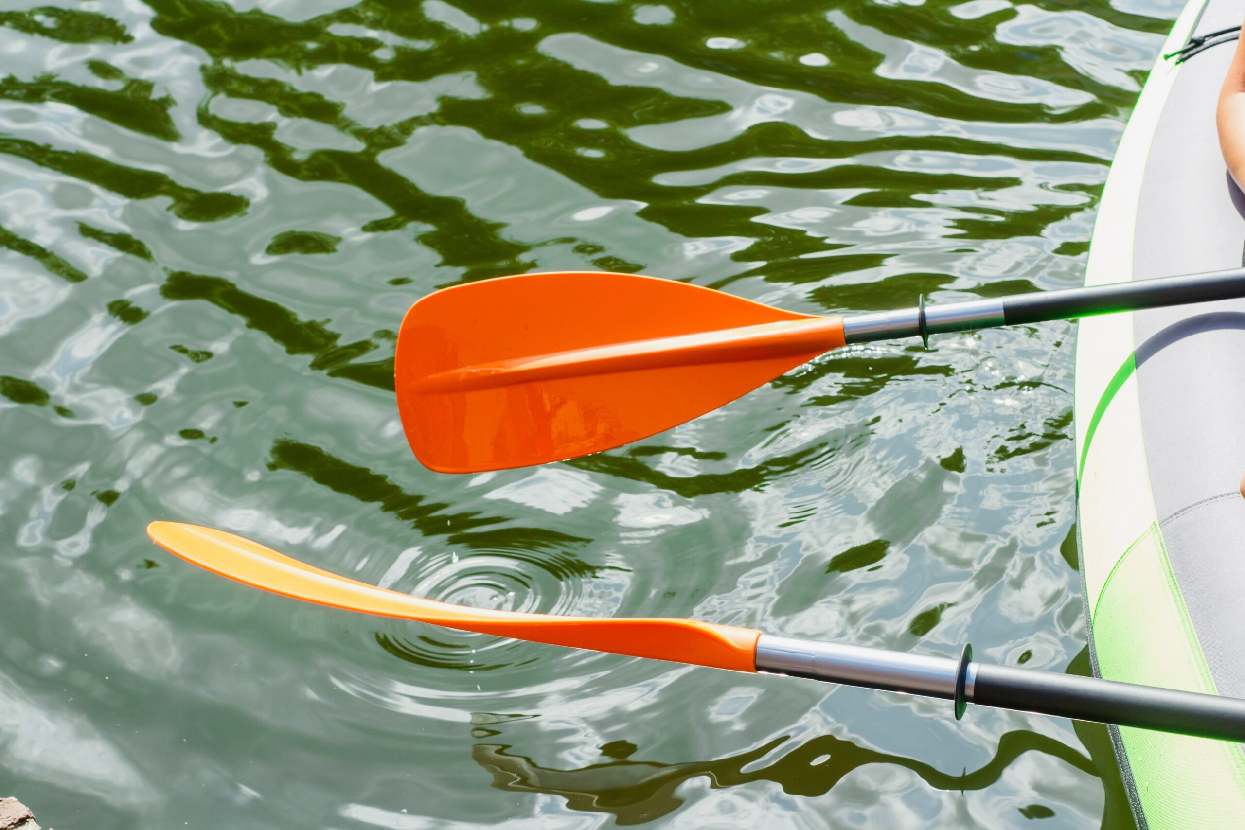 detalhe de remos na lateral de barco inflável em possível aventura curta em rio ou lago