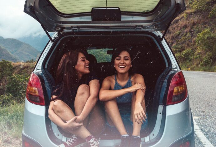 moças no porta malas aberto de um carro em viagem por estrada moças no porta malas aberto de um carro em viagem por estrada