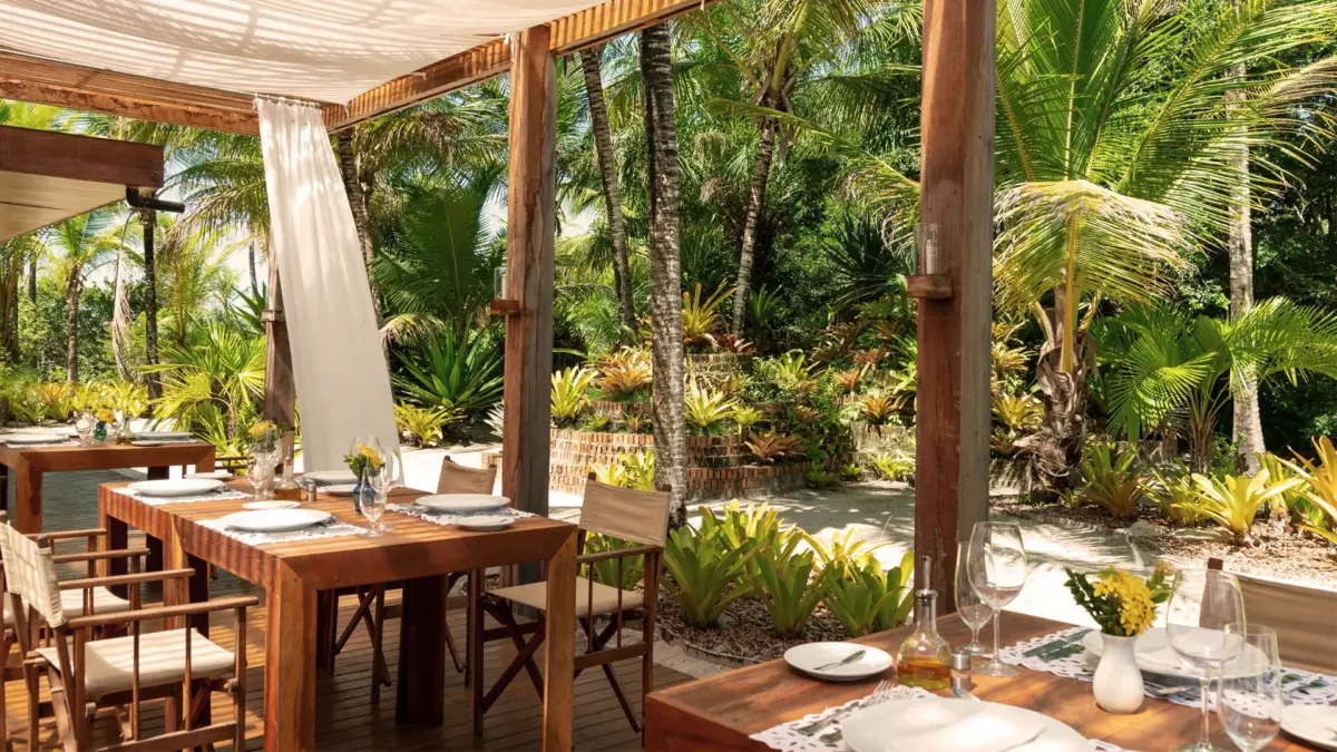 vila-naia6 Restaurante cercado por vegetação.