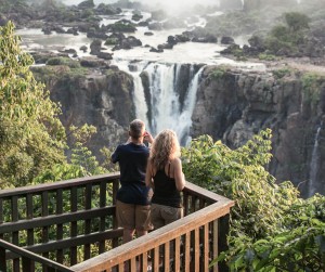 Iguacu Falls, Brazil - November 3, 2014: Tourists are enjoying the view at Iguazu Falls at sunset. The photo is taken on the Brazil side of the falls.