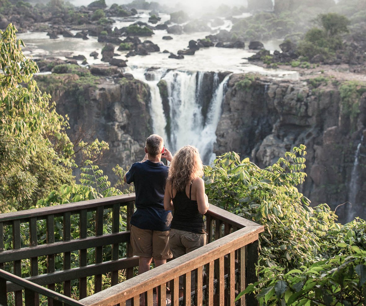 Iguacu Falls, Brazil - November 3, 2014: Tourists are enjoying the view at Iguazu Falls at sunset. The photo is taken on the Brazil side of the falls.