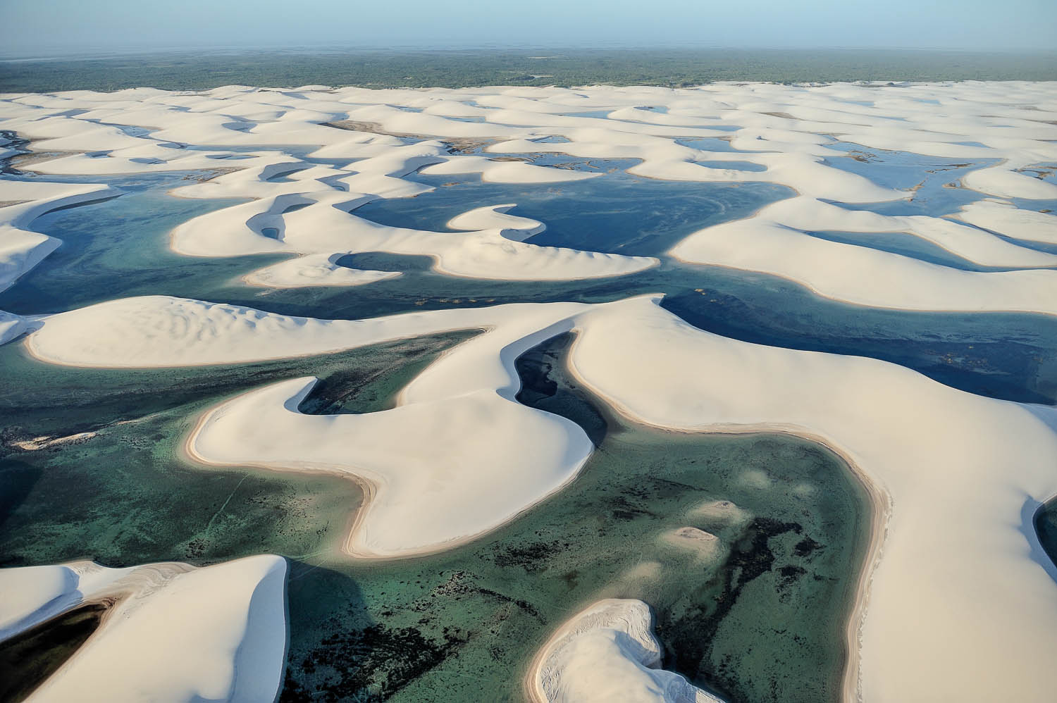 Maranhão state, Brazil – August. 21. 2010 : Aerial view of Lençóis Maranhenses National Park, located in northeastern Brazil, low, flat, occasionally flooded land, overlaid with large, discrete sand dunes with blue and green lagoons